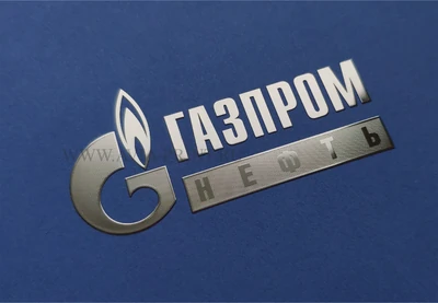 Изготовление металлических никелевых наклеек на заказ с серебряным логотипом Газпром нефть на синем фоне