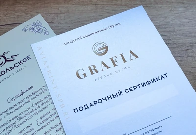 Печать подарочных сертификатов на заказ в белом оформлении с золотым логотипом Grafia